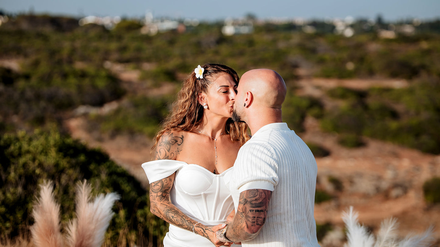 Brautpaar küsst sich bei freier Trauung in der Algarve, romantischer Moment in der Natur