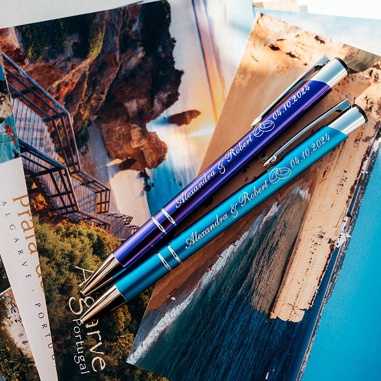 Detailaufnahme personalisierte Hochzeitskugelschreiber mit Namen Alexandra und Robert, Algarve-Postkarten im Hintergrund
