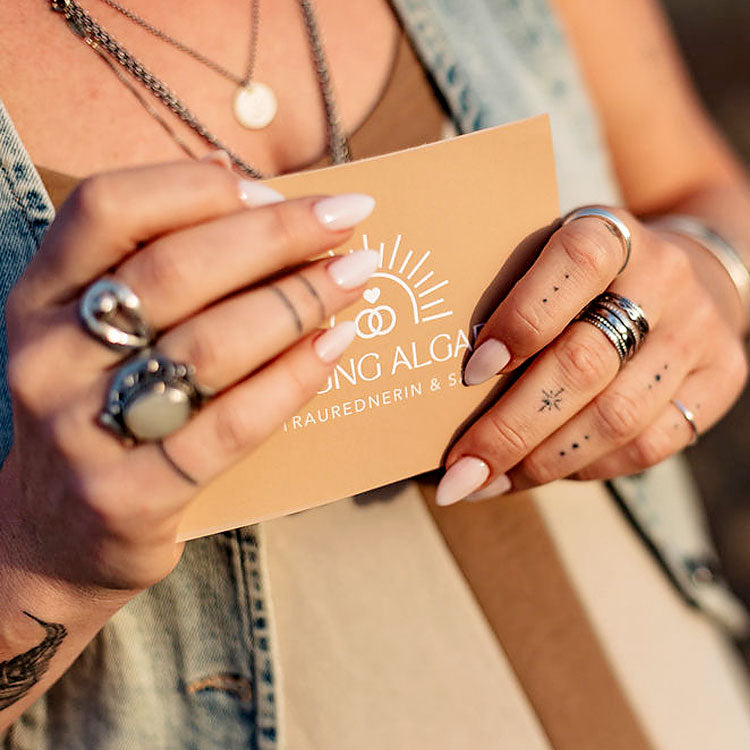 Detailaufnahme mit Schmuck und Karte von Susy Stocky – freie Traurednerin Algarve