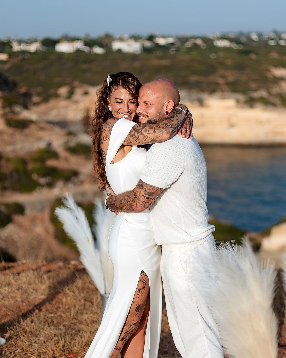 Brautpaar umarmt sich glücklich bei freier Trauung auf den Klippen der Algarve mit Meerblick