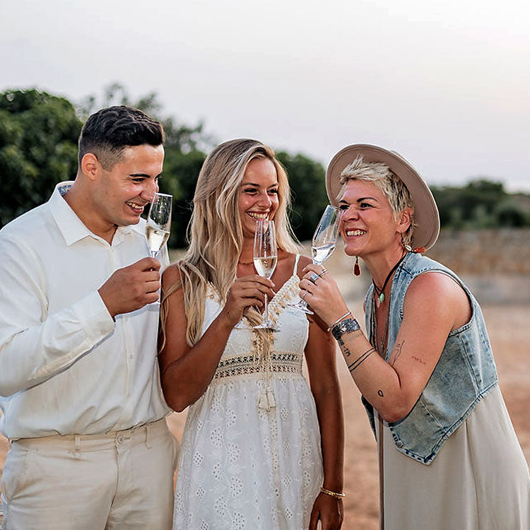 Brautpaar stößt mit Traurednerin nach der freien Trauung in Portugal mit Sektgläsern an