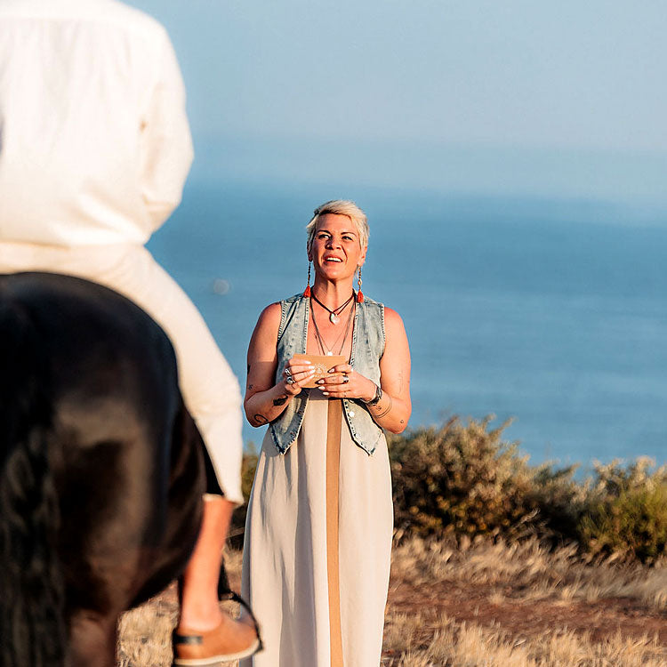 Freie Traurednerin gestaltet eine emotionale Hochzeit an den Klippen der Algarve, Bräutigam sitzt auf schwarzem Pferd