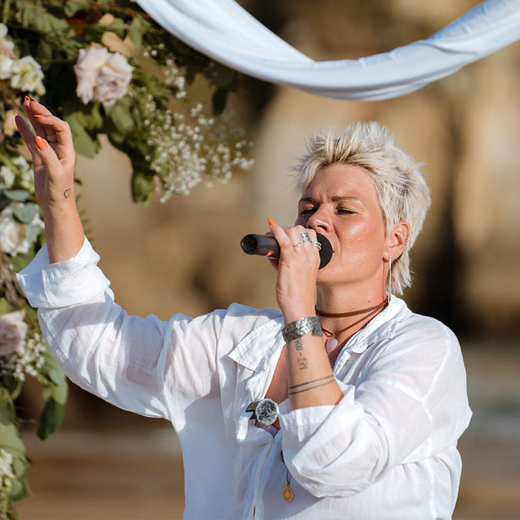 Susy Stocky singt bei einer freien Trauung in der Algarve unter Blumenbogen