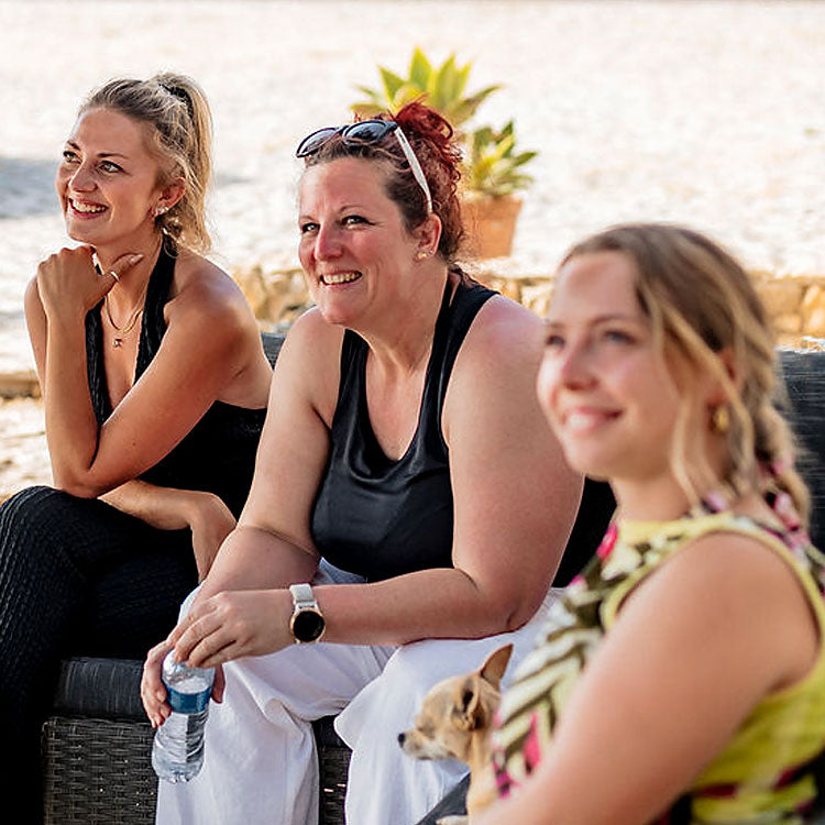 Gäste und Trauzeugen lachen entspannt bei einer freien Trauung in Portugal am Strand